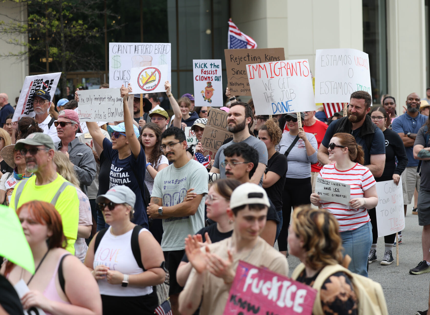 People hold signs at No Kings rally.JPG